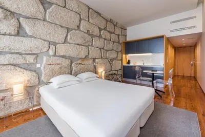 a small table in a kitchen with a stone wall at GuestReady - Porto de Rio Residences in Porto