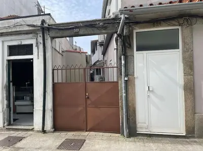 an open garage with two doors on a building at Bessa - Casinha Típica do Porto com dois quartos in Porto