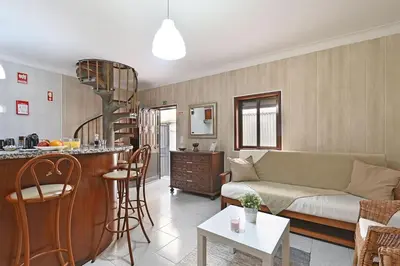 a living room with a couch and a kitchen at Bessa - Casinha Típica do Porto com dois quartos in Porto