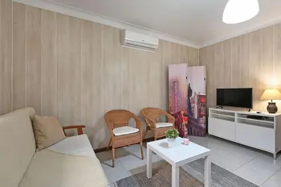 a living room with a couch and chairs and a tv at Bessa - Casinha Típica do Porto com dois quartos in Porto