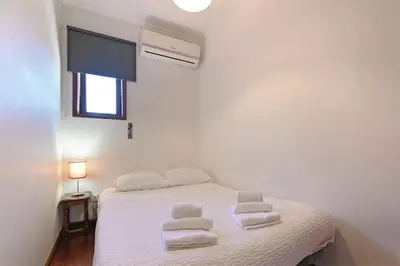 a bedroom with a white bed with towels on it at Bessa - Casinha Típica do Porto com dois quartos in Porto