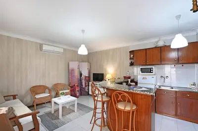 a kitchen and a living room with a table and chairs at Bessa - Casinha Típica do Porto com dois quartos in Porto
