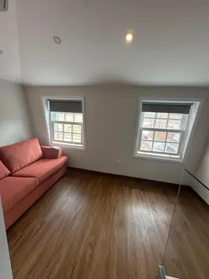 a living room with a red couch and two windows at Bridge Apartment in Porto