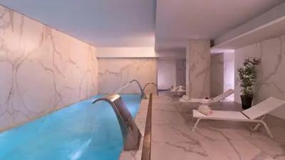 a swimming pool in a hotel room with a spa at NH Collection Porto Batalha in Porto