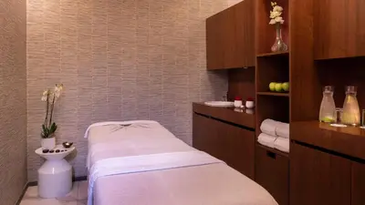 a small bathroom with a bed and a sink at NH Collection Porto Batalha in Porto