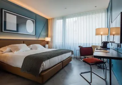 a hotel room with a bed and a desk and a chair at Vincci Porto in Porto