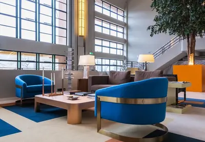 a lobby with a blue chair and a table at Vincci Porto in Porto