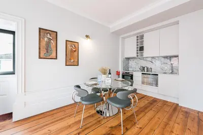 a white dining room with a table and chairs at GuestReady - Prince's Palace - HighLife in Porto