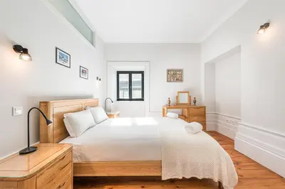 a white bedroom with a bed and a television at GuestReady - Prince's Palace - HighLife in Porto