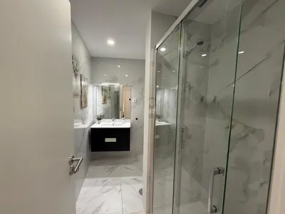 a bathroom with a glass shower and a sink at ML Porto Plaza Avenue in Porto
