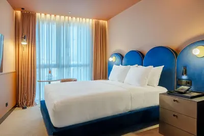a bedroom with a large bed with a blue headboard at Cenica Porto Hotel, Curio Collection By Hilton in Porto
