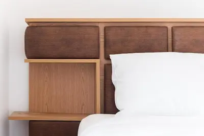 a bed with a wooden headboard and a white pillow at GuestReady - Over the Bridge in Porto