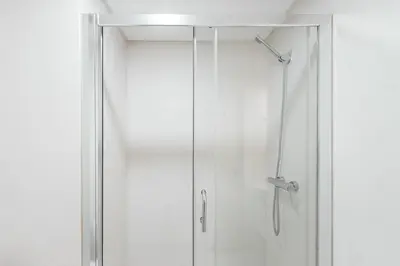 a shower with a glass door in a bathroom at GuestReady - Over the Bridge in Porto