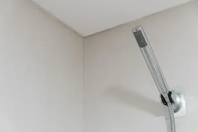 a shower in a bathroom with a white wall at GuestReady - Over the Bridge in Porto