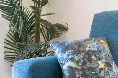 a blue couch with a pillow next to a plant at GuestReady - Over the Bridge in Porto