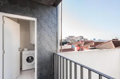 a balcony with a washing machine and a window at GuestReady - Over the Bridge in Porto
