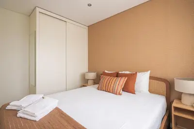 a bedroom with a bed with white sheets and pillows at Cedofeita Bliss - 1BDR with AC in Porto