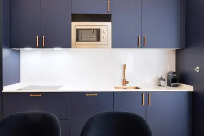 a kitchen with blue cabinets and a microwave at Cardosas Block Luxury Apartment in Porto