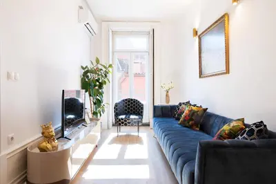 a living room with a blue couch and a tv at Cardosas Block Luxury Apartment in Porto