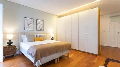 a bedroom with a bed and a large white closet at Fábrica Three-Story Charm by LovelyStay in Porto