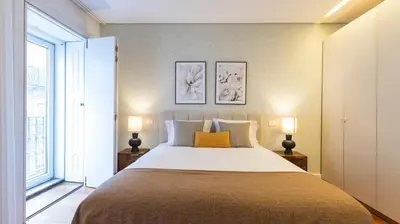 a bedroom with a large bed with two lamps at Fábrica Three-Story Charm by LovelyStay in Porto