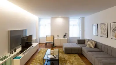 a living room with a couch and a flat screen tv at Fábrica Three-Story Charm by LovelyStay in Porto