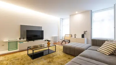 a living room with a couch and a flat screen tv at Fábrica Three-Story Charm by LovelyStay in Porto
