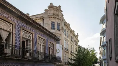 a building with a clock tower on top of it at Fábrica Three-Story Charm by LovelyStay in Porto