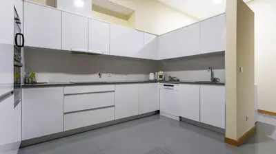 a white kitchen with white cabinets and a sink at Mouzinho's Place by LovelyStay in Porto