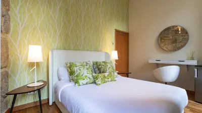 a bedroom with a white bed with green patterns on the wall at Mouzinho's Place by LovelyStay in Porto