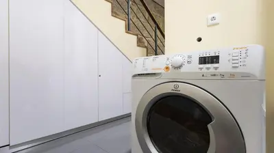 a washing machine in a room with white cabinets at Mouzinho's Place by LovelyStay in Porto