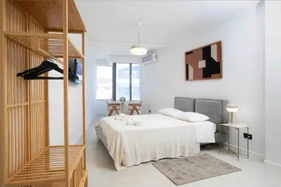 a white bedroom with a bed and a staircase at Oporto Charming Studio Gaia in Vila Nova de Gaia