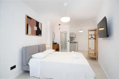 a white bedroom with a bed and a tv at Oporto Charming Studio Gaia in Vila Nova de Gaia