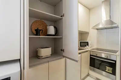 a kitchen with white cabinets and a microwave at Apartment in city center in Porto