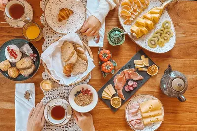 a wooden table with plates of food and cups of coffee at The Lost Garden in Vila Nova de Gaia