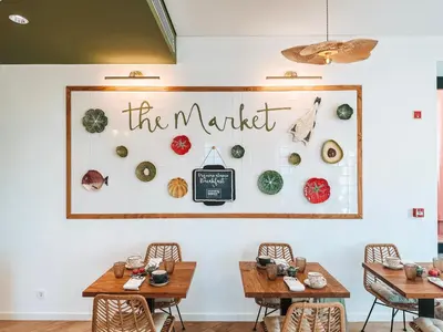 a restaurant with tables and a sign that reads the market at The Lost Garden in Vila Nova de Gaia
