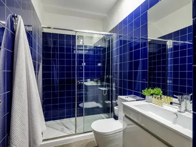 a blue tiled bathroom with a toilet and a sink at Oporto View Apartments in Porto