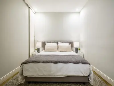 a bedroom with a large bed with white walls at Oporto View Apartments in Porto