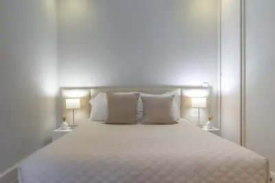 a bedroom with a large white bed with two lamps at Oporto View Apartments in Porto