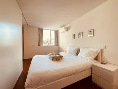 a bedroom with a large white bed with a bag on it at Bombarda H in Porto