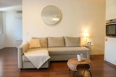 a living room with a couch and a mirror at Bombarda H in Porto