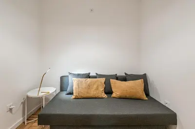 a bed in a room with a white wall at GuestReady - Hospitality Atrium - Leite Residence in Vila Nova de Gaia