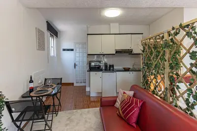 a living room with a red couch and a kitchen at Dream Bonfim in Porto
