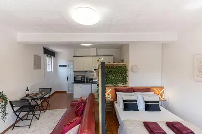 a living room with a bed and a kitchen at Dream Bonfim in Porto