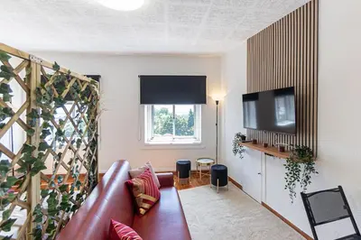 a living room with a leather couch and a television at Dream Bonfim in Porto