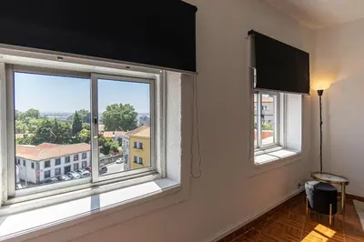 a room with two windows with a view of a city at Dream Bonfim in Porto