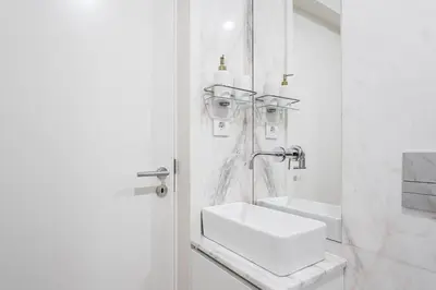 a white bathroom with a sink and a mirror at GuestReady - Porto's Modern Comfort in Porto