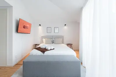 a bedroom with a large bed with a blue ottoman at GuestReady - Porto's Modern Comfort in Porto