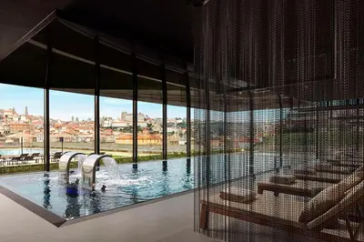 a gym with a bunch of exercise equipment in a room at Tivoli Kopke Porto Gaia Hotel in Vila Nova de Gaia