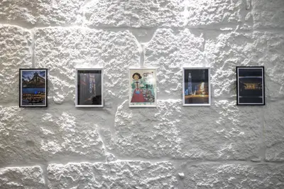 a wall with four pictures on a white brick wall at ApartmentsPorto - Apartamento Belas Artes in Porto